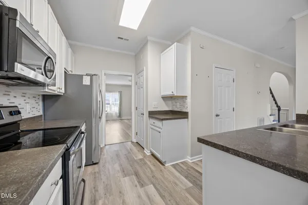 a kitchen with white cabinets and appliances