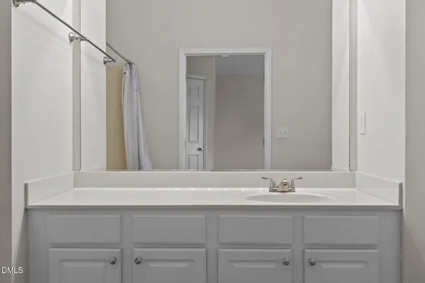 a spacious bathroom with a bathtub a mirror a vanity and a shower