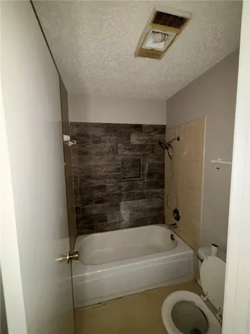 a bathroom with a shower a toilet and a bathtub