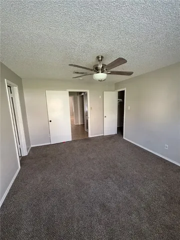 a view of an empty room with a chandelier fan