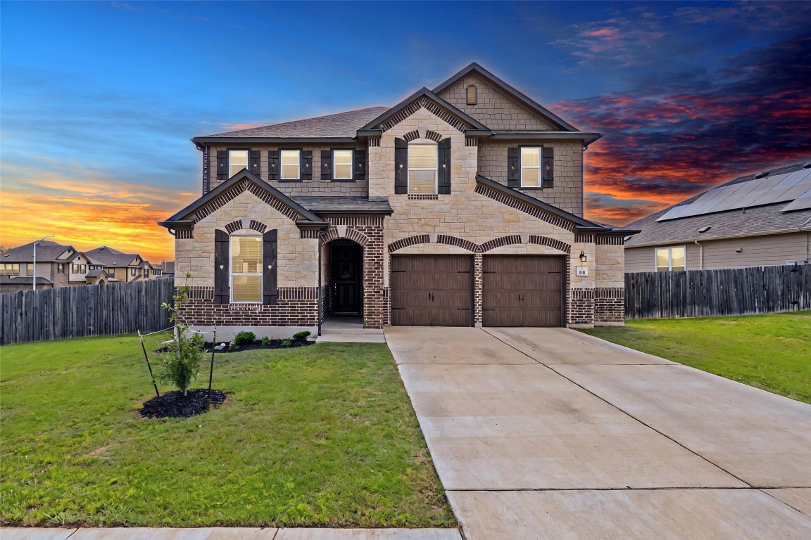 a front view of a house with a yard and garage