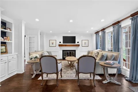 a living room with furniture a rug and kitchen view