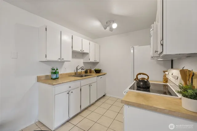 a kitchen with a refrigerator sink and cabinets