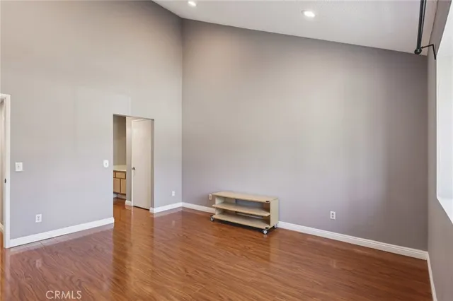 a view of empty room with wooden floor and window