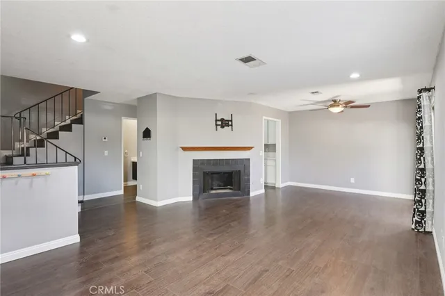 a view of a big room with wooden floor and windows