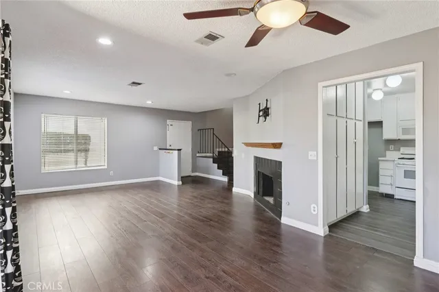 a kitchen with stainless steel appliances a sink dishwasher stove and white cabinets with wooden floor