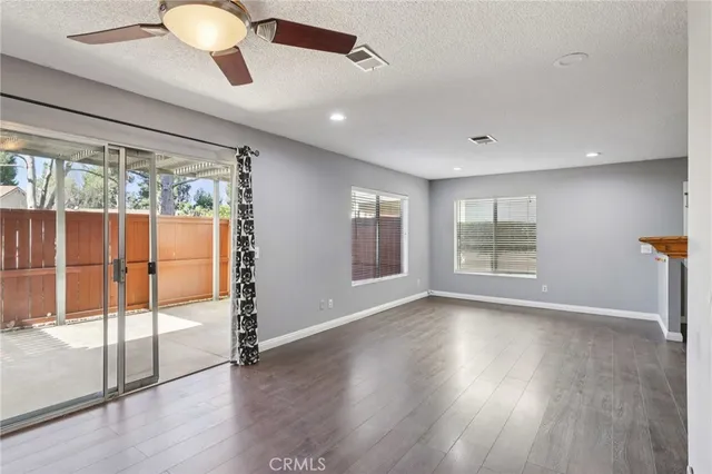 a kitchen with stainless steel appliances granite countertop a sink dishwasher a stove and white cabinets with wooden floor