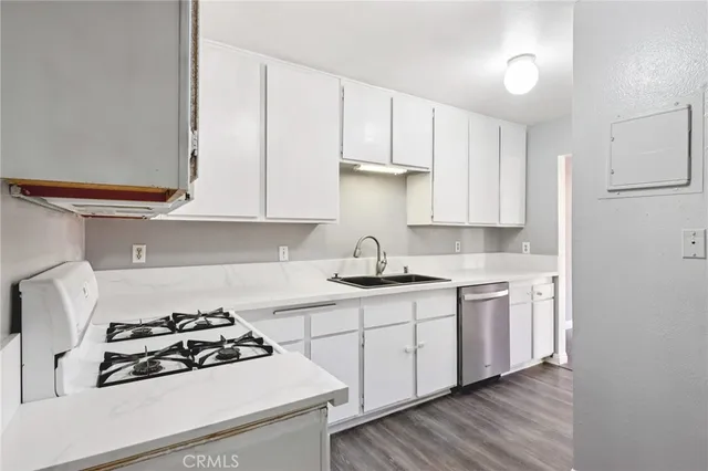 a kitchen with stainless steel appliances a white stove top oven and sink