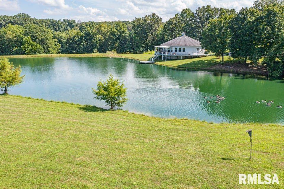 14290 East Windsong Road Mount Vernon, IL 62864 - Photo 3 of 21 a view of a lake with a house in the background