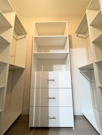 a view of staircase with white walls and white door