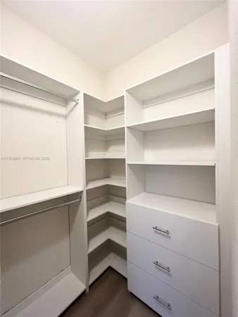 a view of walk in closet with empty racks