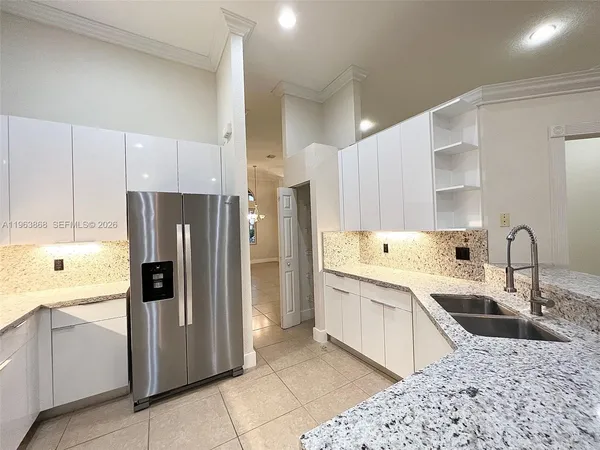 a kitchen with a sink a refrigerator and cabinets