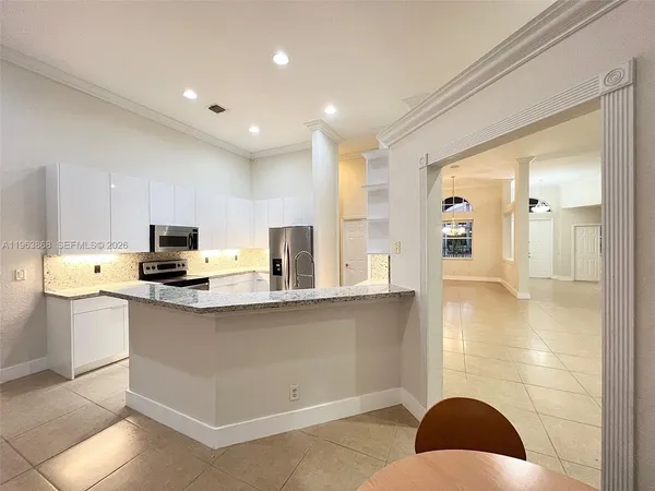 a kitchen with stainless steel appliances granite countertop a sink a stove a refrigerator a microwave a counter top and cabinets