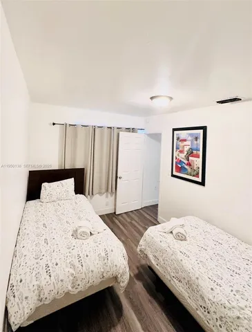 a bedroom with a bed and a refrigerator