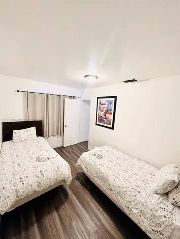 a bedroom with a bed and a refrigerator