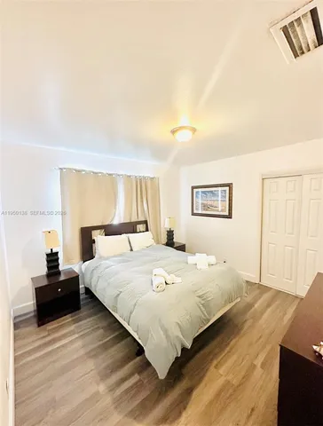 a spacious bedroom with a bed and a window