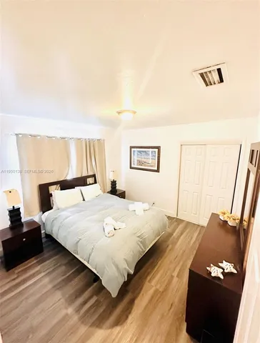 a bedroom with a bed and wooden floor