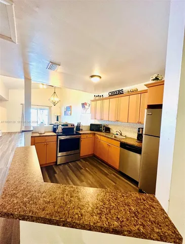 a kitchen with stainless steel appliances kitchen island granite countertop a refrigerator and stove