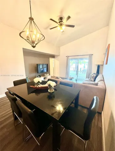 a view of a dining room with furniture and a chandelier