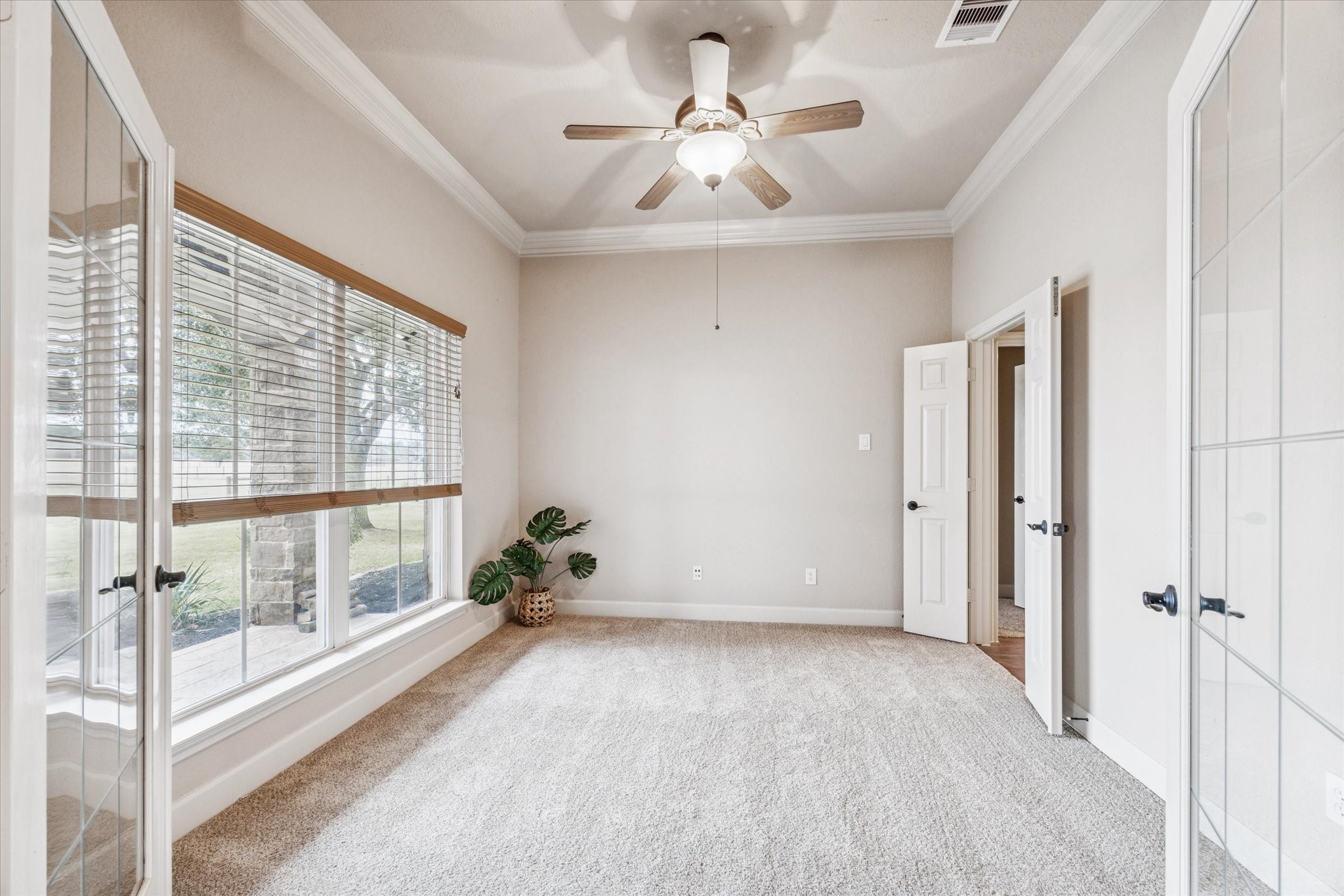 11256 Hahn Road Sealy, TX 77474 - Photo 7 of 24 A home office located at the front of the home features glass French doors, offering a quiet, light-filled workspace that balances privacy with an open, airy feel.