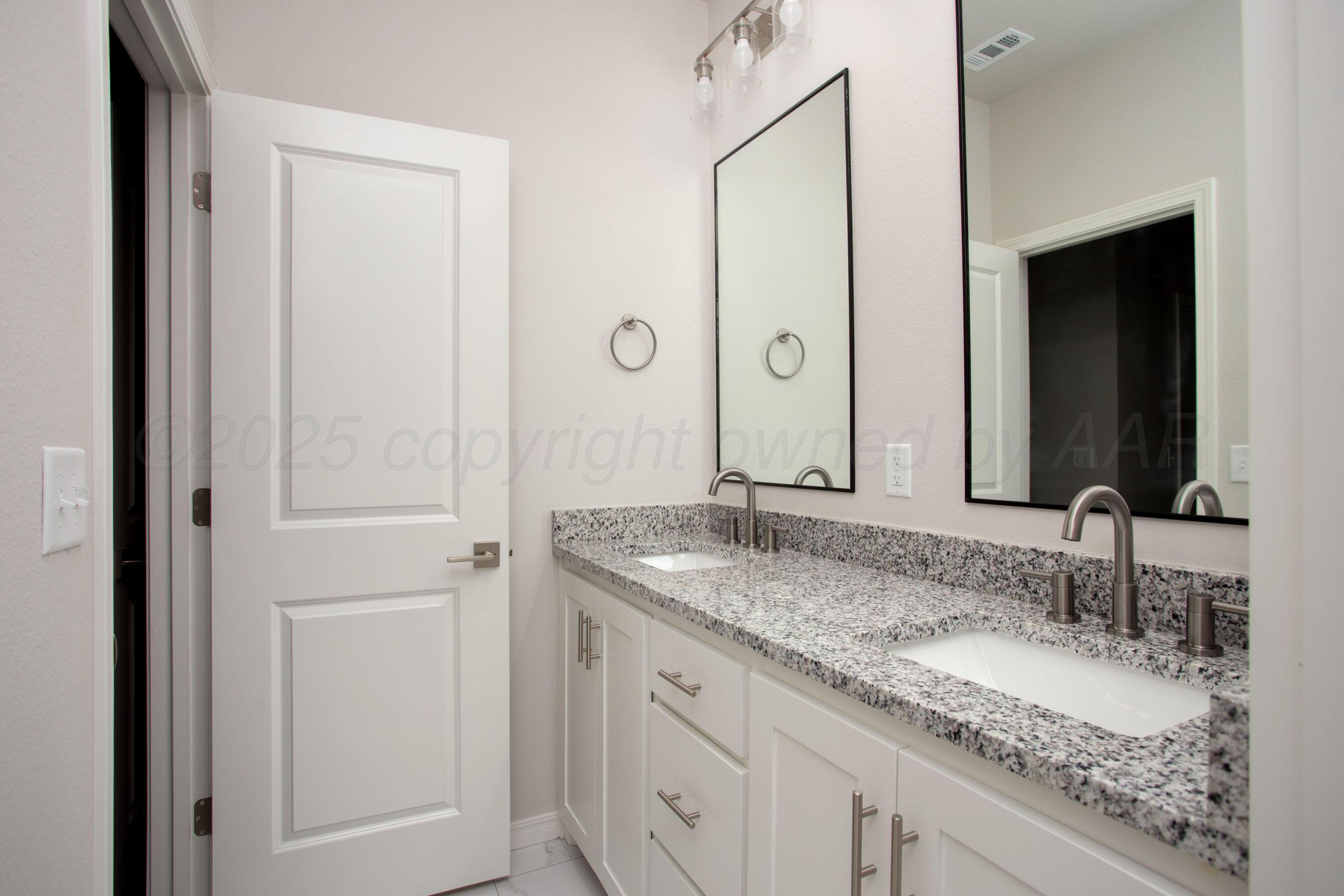 22131 Howard Draw Rd Canyon Canyon, TX 79015 - Photo 12 of 25 a bathroom with a granite countertop double vanity sink and a mirror