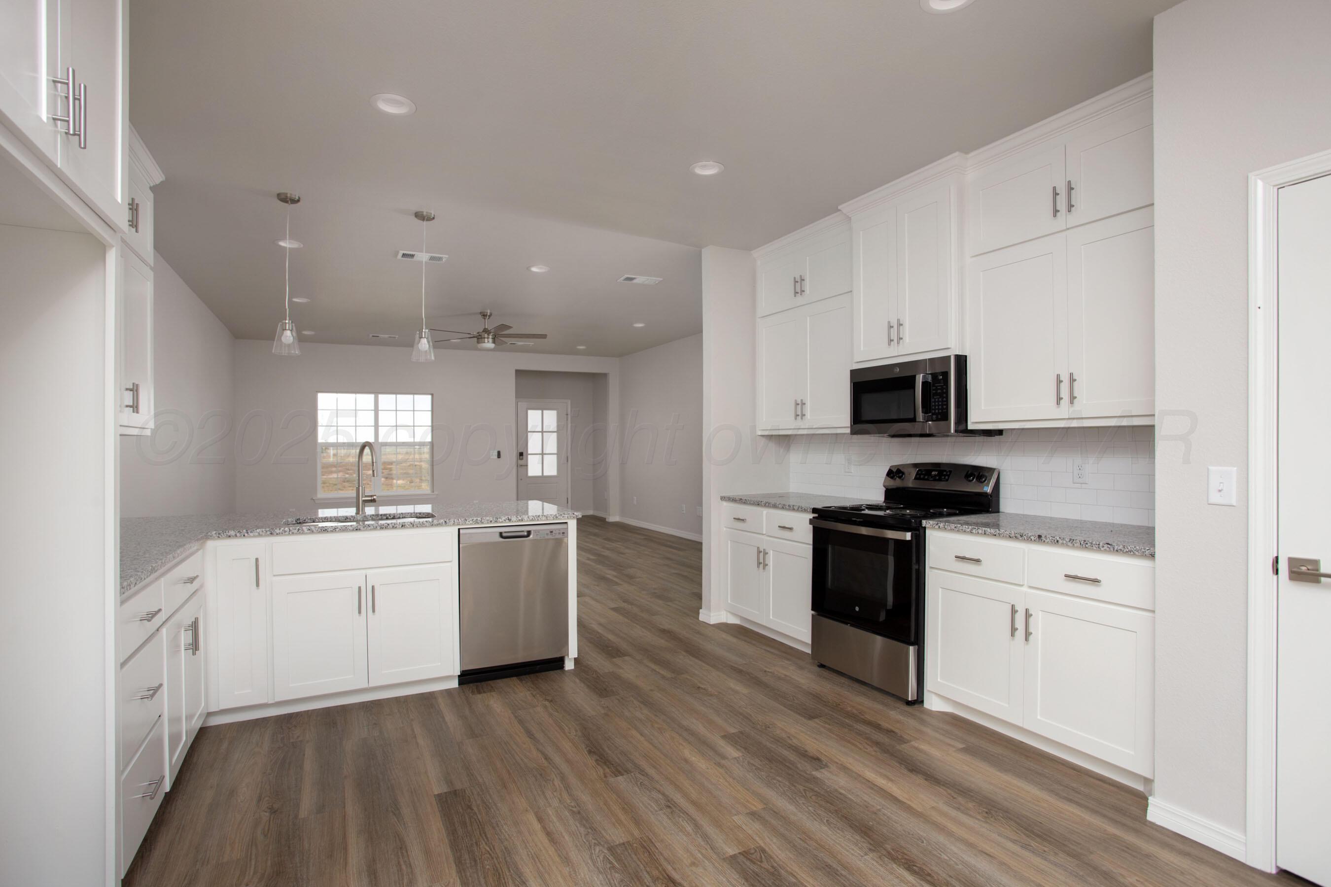 22131 Howard Draw Rd Canyon Canyon, TX 79015 - Photo 5 of 25 a kitchen with a white stove top oven and white cabinets