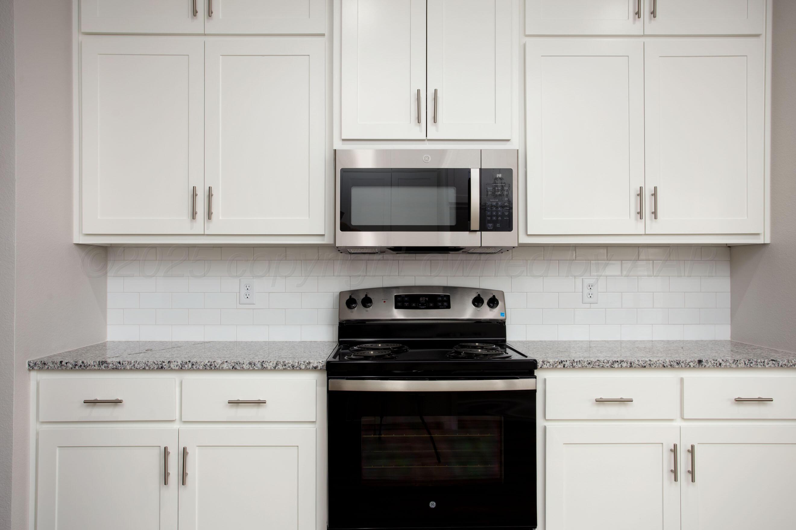 22131 Howard Draw Rd Canyon Canyon, TX 79015 - Photo 7 of 25 a kitchen with white cabinets and black appliances