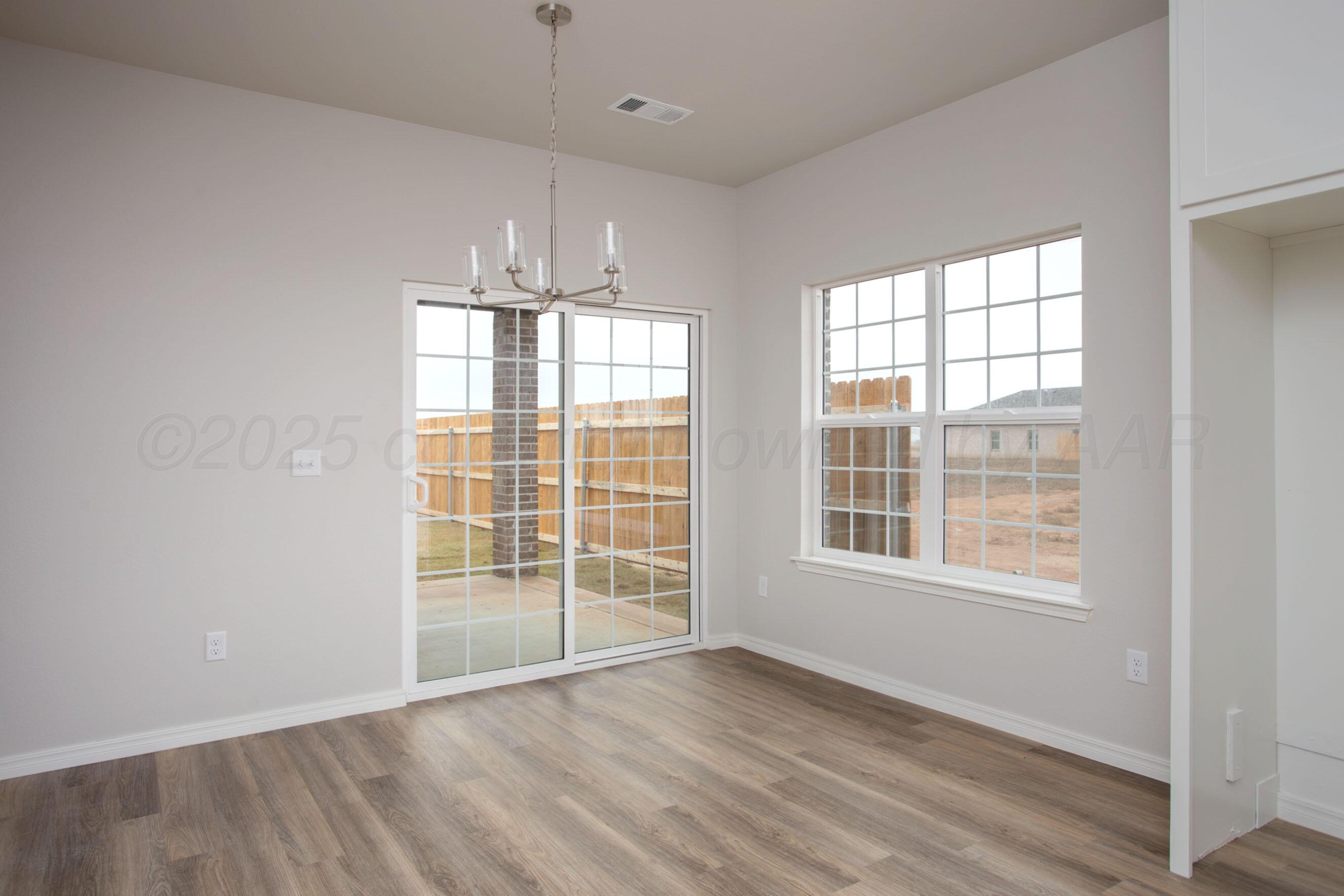 22131 Howard Draw Rd Canyon Canyon, TX 79015 - Photo 8 of 25 an empty room with wooden floor and windows
