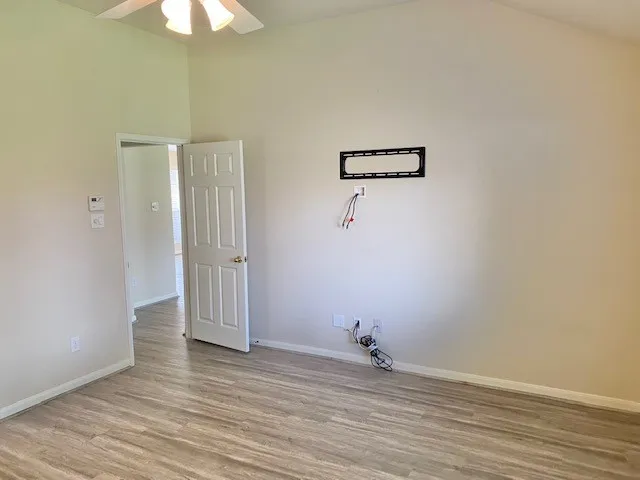 a view of a room with wooden floor and a ceiling fan