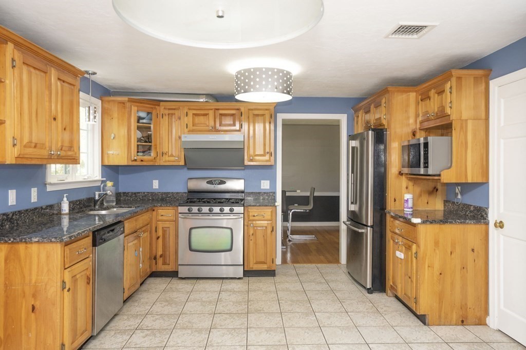 2 Toni Lane Franklin, MA 02038 - Photo 7 of 24 a kitchen with stainless steel appliances granite countertop a stove a sink and a refrigerator