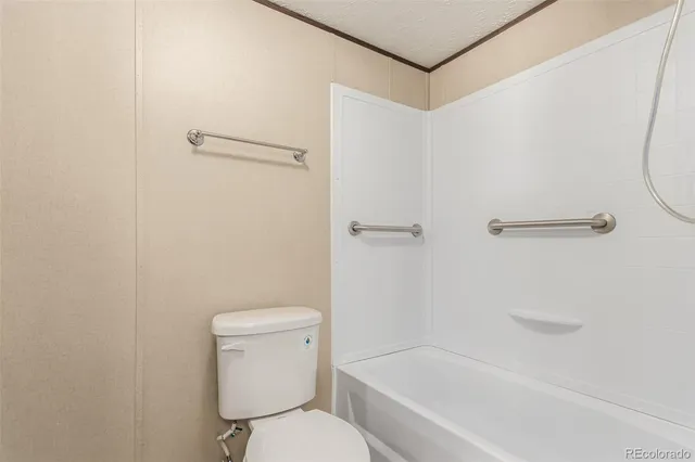 a white toilet sitting next to a bath tub
