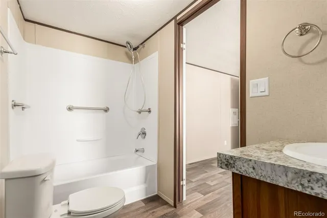 a bathroom with a granite countertop sink toilet and shower