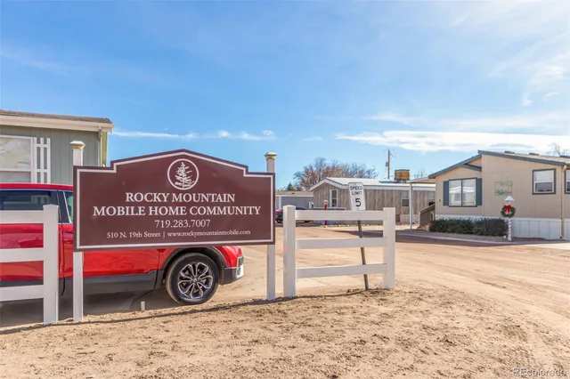 an aerial view of a city with lots of residential buildings and mountain view in back