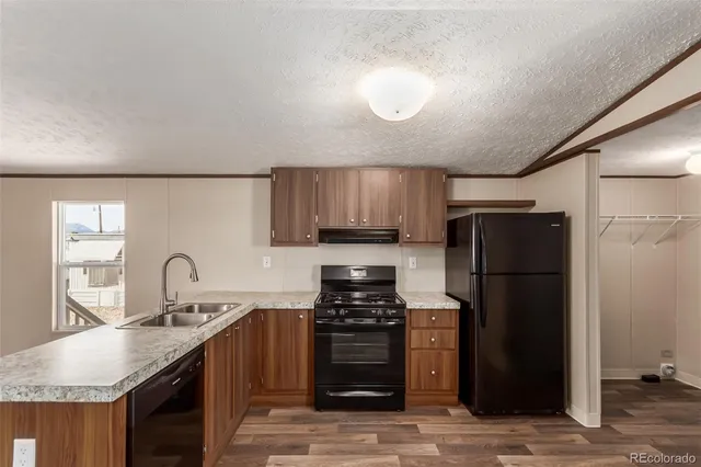 a kitchen with granite countertop a refrigerator stove and sink