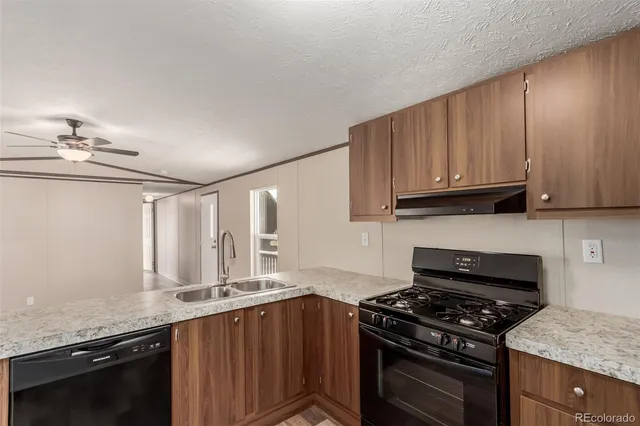a kitchen with granite countertop a stove and a sink