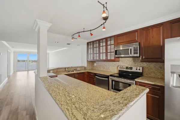 a kitchen with stainless steel appliances granite countertop a sink stove and refrigerator
