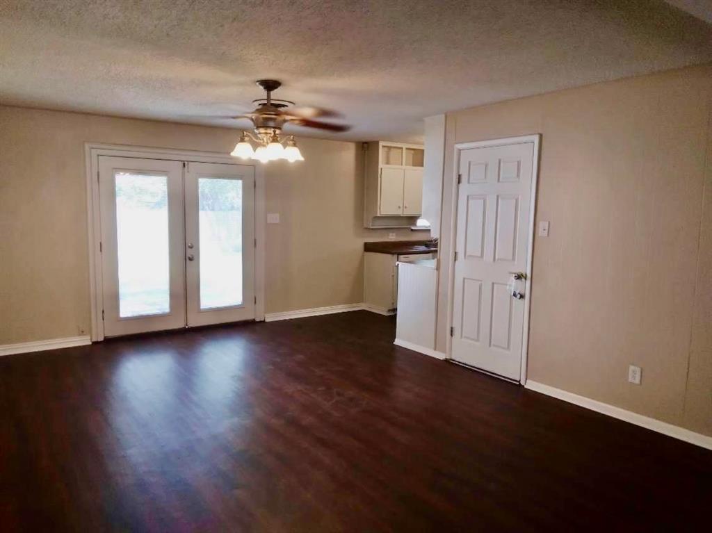 913 Irwin Drive Hurst, TX 76053 - Photo 2 of 8 a view of a room with wooden floor ceiling fan and windows