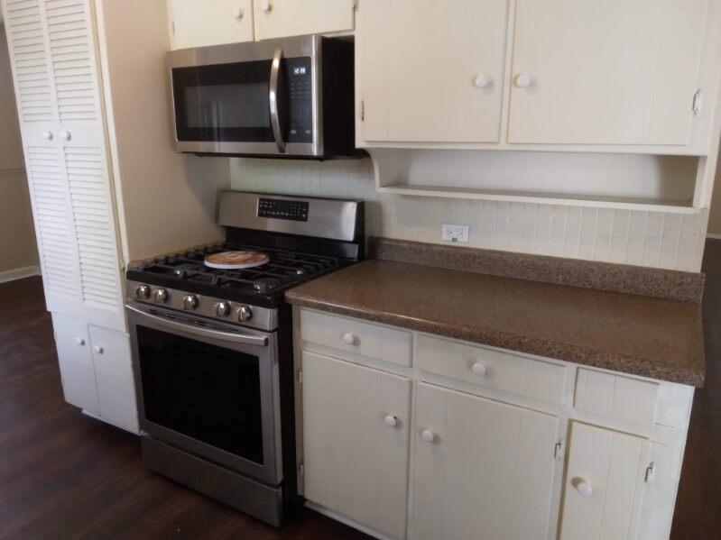 913 Irwin Drive Hurst, TX 76053 - Photo 4 of 8 a kitchen with stainless steel appliances granite countertop white cabinets and black stove top oven with granite countertops