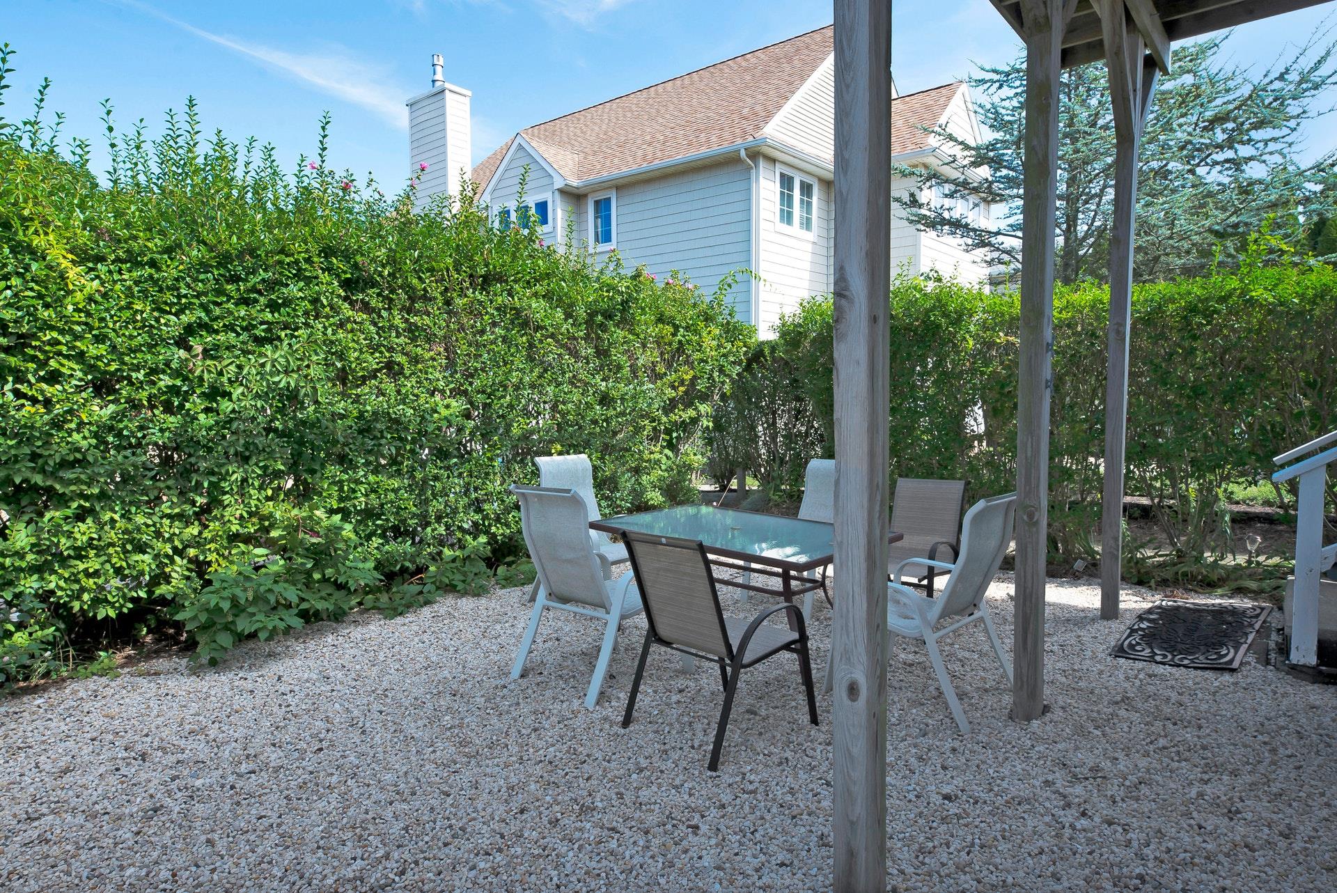 11 Oakhurst Road Hampton Bays, NY 11946 - Photo 16 of 20 a view of a patio with table and chairs and potted plants