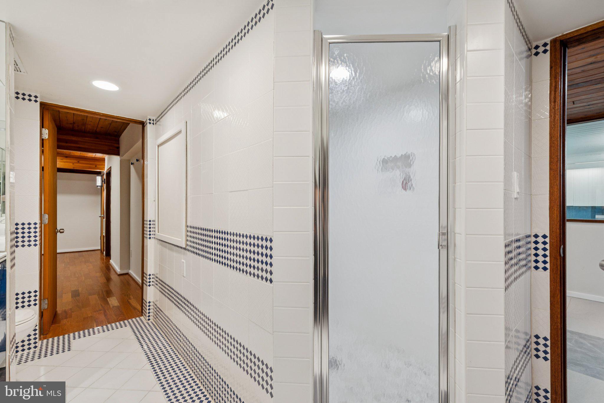 11428 Purple Beech Drive Reston, VA 20191 - Photo 47 of 52 a view of a hallway with wooden floor and bathroom