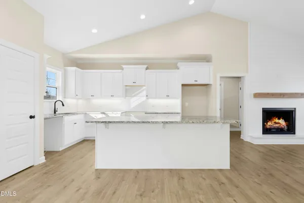 a kitchen with granite countertop a stove a sink and a refrigerator