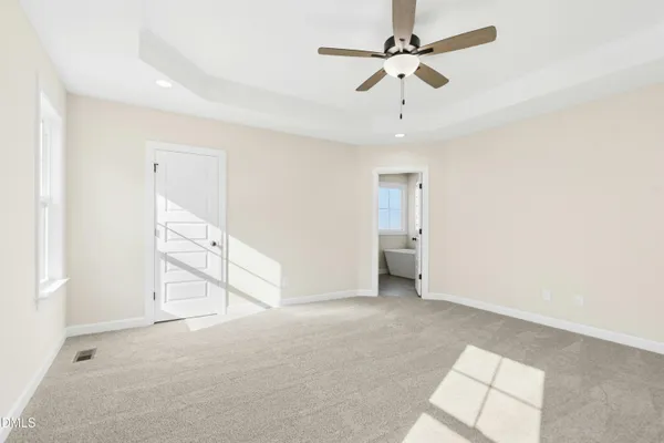 an empty room with fan and windows