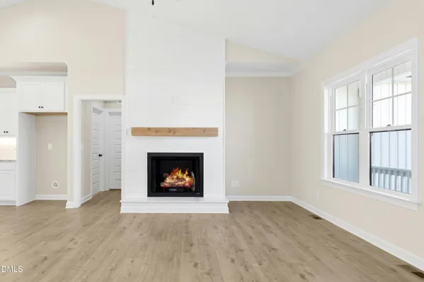 a view of an empty room with a window and fireplace