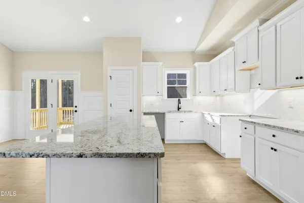 a kitchen with granite countertop white cabinets and white appliances