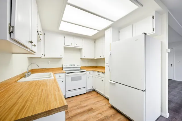 a kitchen with a refrigerator and white cabinets