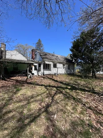 a view of a house with backyard and a tree