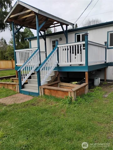 a view of a house with a deck and a yard
