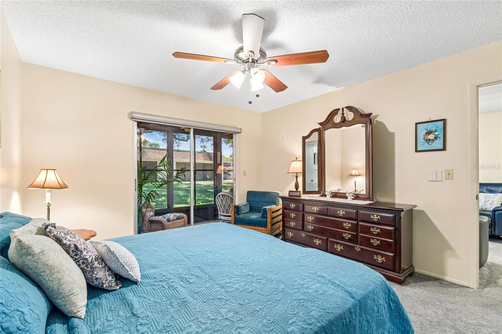 11340 Carriage Hill Drive, Unit 4 Port Richey, FL 34668 - Photo 4 of 36 a bedroom with a bed and a chandelier