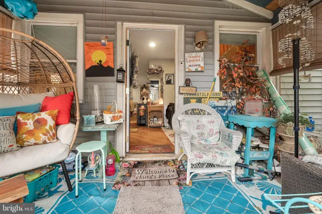 an outdoor living room with patio furniture and potted plants