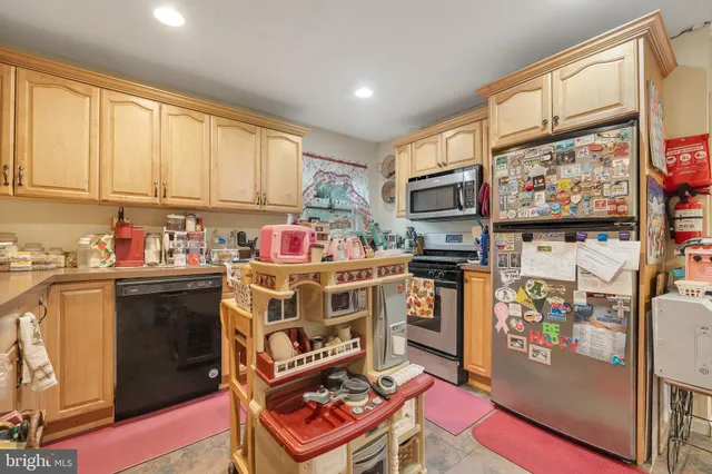 a kitchen with stainless steel appliances a stove top oven a refrigerator and cabinets